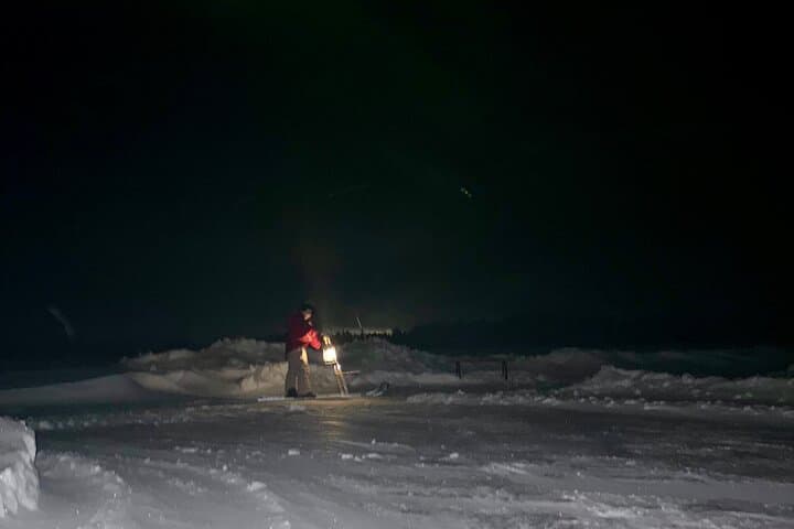 Gliding across the frozen lake under the arctic night sky